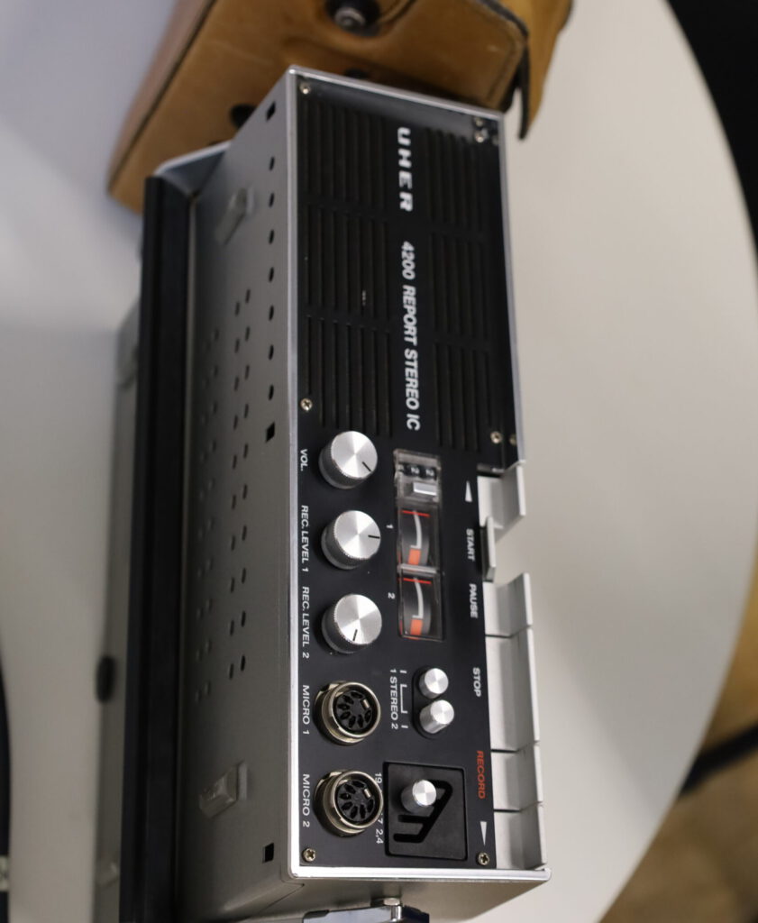 Nahaufnahme eines tragbaren UHER 4200 Report Stereo IC Tonbandgeräts aus den 1970er Jahren mit Bedienelementen, Pegelanzeigen und sichtbarem Tonbandbereich.